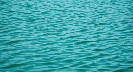 Gentle turquoise water ripples creating a calming and abstract background texture with a vibrant and dynamic fluid motion in a natural outdoor setting