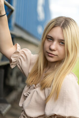 Portrait of a young beautiful blonde girl on the railway on a summer day.
