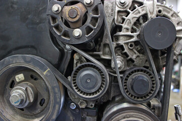 Overhaul of the timing belt mechanism of the gasoline engine on a workbench at a car shop. Dismantled from car engine on a checking stand for repair  
