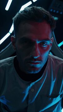 Homme dans un environnement futuriste &eacute;clair&eacute; de n&eacute;ons bleus et rouges, regard intense

