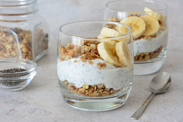 a dessert in a drinking glass with Yogurt, Granola and Bananas