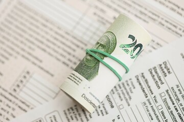 Mexican pesos money bills in big amount lies on table with tax forms close up