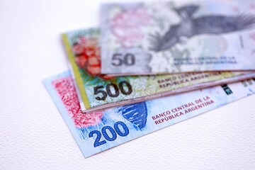 Argentine pesos money bills in big amount lies on white table close up