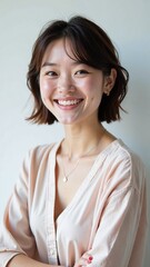 Fototapeta premium Smiling young Asian woman in pink blouse with copy space for marketing materials, perfect for advertising campaigns, website hero image, or corporate presentation backdrop with neutral background