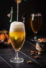 Glass of light beer on dark background. Selective focus