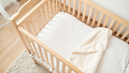 Cozy crib with soft blanket in a bright nursery room  