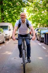 Obraz premium Middle aged man using a bicycle on the city