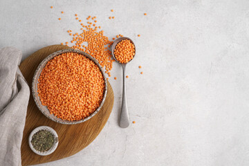 Red lentils in ceramic plate on gray background. top view, copy space