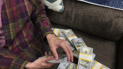 Young Woman Counts Stacks of Cash $100 Bills