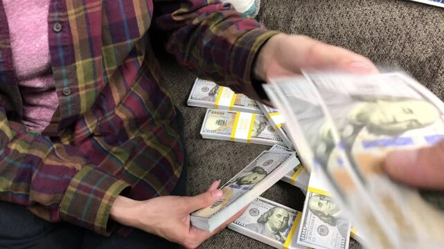 Young Woman Counts Stacks of Cash $100 Bills