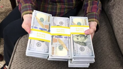 Young Woman Counts Stacks of Cash $100 Bills