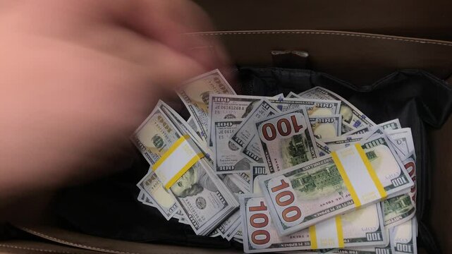 Young Man Handles Cash In Suitcase