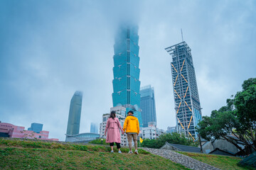 Obraz premium Sweet Couple Standing Near Foggy Taipei 101 – Urban Travel Scene in Taiwan