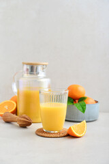 Orange fresh squeezed juice in glass and glasses jug