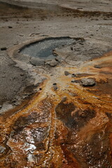 Beautiful hot spring with rusting gold brown copper colored liquid at Yellowstone National Park Wyoming