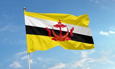 Brunei national flag featuring yellow field with black and white stripes and red crest waving against a clear blue sky