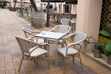 Outdoor cafe setting with empty chairs and table on a quiet urban street