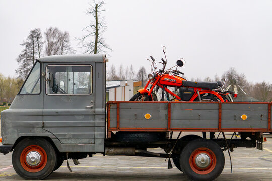 grey Żuk in a box version carrying a red Romet Ogar 200 on the bed. Both vehicles bear the traces of time, but this only adds to their charm and authenticity. It is a scene from the old days