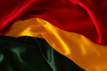 Black History Month, Juneteenth background. Red, yellow, green colors satin silk flag draperies. Top view