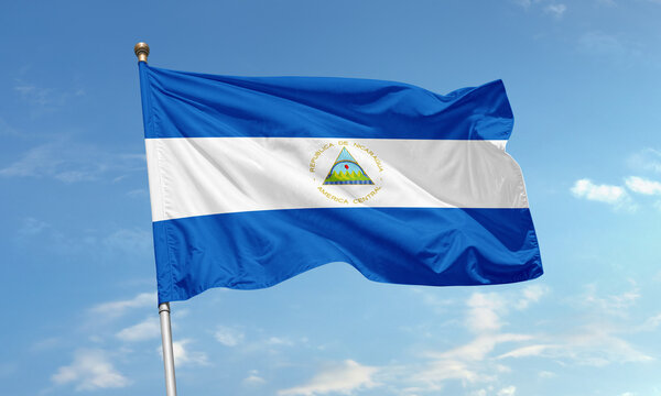 Nicaraguan national flag with blue and white stripes waving in clear sky - Powered by Adobe