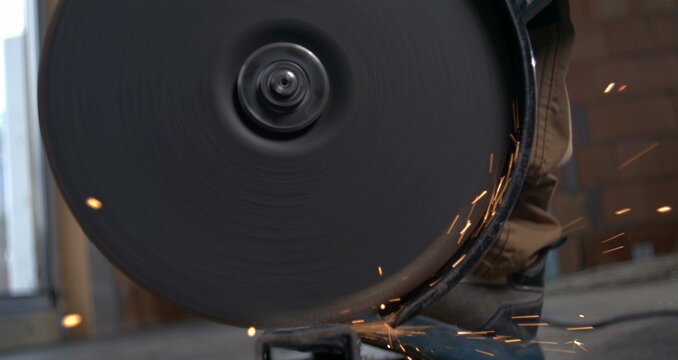 Angle grinder cutting through metal pipe, sparks flying in super slow motion at 800 fps, showcasing industrial precision, metalworking, and craftsmanship details - Powered by Adobe
