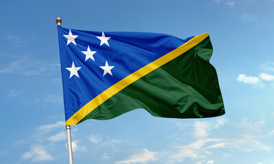 Solomon Islands flag flying with blue sky