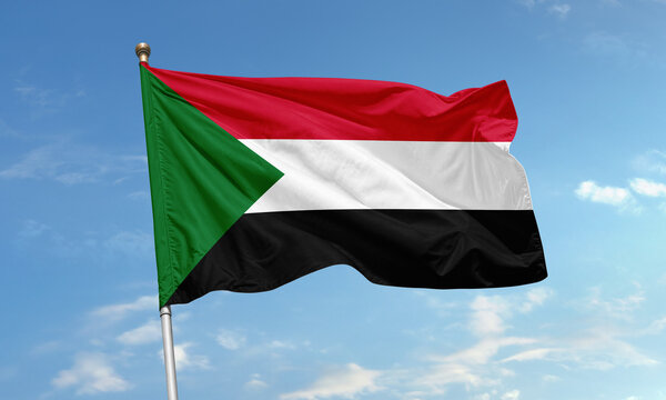 Sudan national flag flying in blue sky