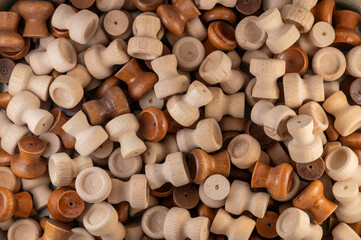 A pile of wooden drawer knobs or handles in various natural shades, showcasing craftsmanship, woodworking, and rustic home decor materials