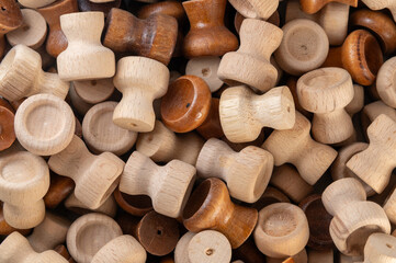 A pile of wooden drawer knobs or handles in various natural shades, showcasing craftsmanship, woodworking, and rustic home decor materials