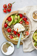 Gluten Free Bowl with Quinoa, Avocado, Cherry Tomatoes, Poached Egg and Walnuts for breakfast. vegeterian dish