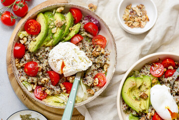 Gluten Free Bowl with Quinoa, Avocado, Cherry Tomatoes, Poached Egg and Walnuts for breakfast. vegeterian dish