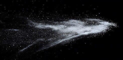 Fine white powder explosion against black background