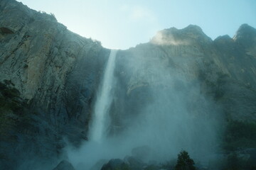 Scenery with granite cliffs, greenery, cascading waterfalls blue skies at Yosemite National Park in California’s Sierra Nevada mountains