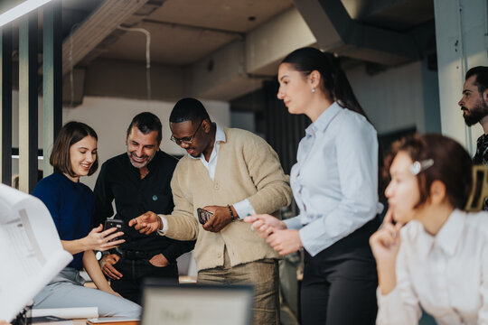 A group of diverse business people engage in a collaborative discussion in a modern office. The atmosphere is focused yet friendly, showcasing teamwork and multicultural interaction.