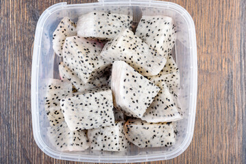 Sliced pieces of fresh pitahaya pulp in a plastic container.