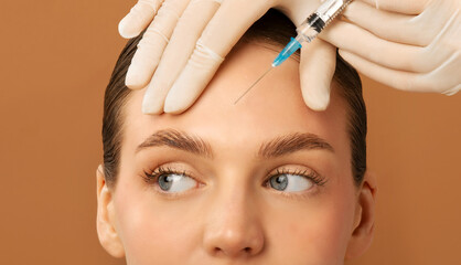 Injection cosmetology. Beautician making beauty shot to lady's forehead, woman getting anti-wrinkle...