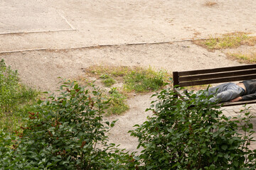 A man sleeps on a street bench in Ukraine, a drunk man rests on a bench in the yard