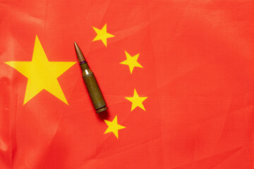 Flag of China with a bullet, symbol of war, weapons and aggression against the backdrop of...