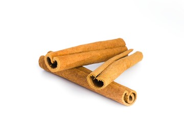 Collection of cinnamon bark fragments on a white backdrop, capturing their natural beauty and spice characteristics.