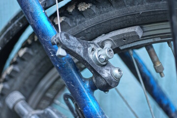 one black front brake on blue frame uu wheel rim on bicycle on city street