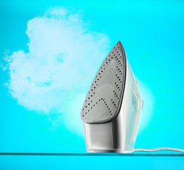 Steam coming from the iron. Iron and steam on a blue background. Isolated iron.