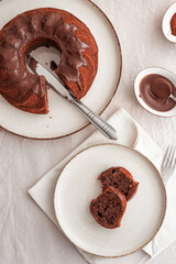 Chocolate cake with chocolate icing on white wooden table. Top view