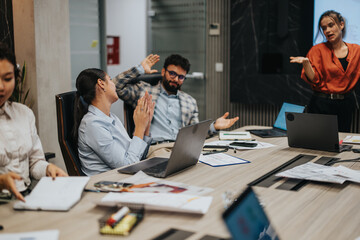 Multigenerational group of business colleagues collaborates in a modern office setting, discuss project ideas and strategies for growth. The diverse team is engaged in a productive late-night meeting.