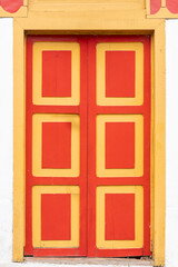 A colorful exterior facade. Vibrant Wooden Colonial Door in Traditional Style. Colombian fecade