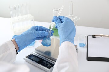 Fototapeta na wymiar Scientist working with sample and scales at white table, closeup