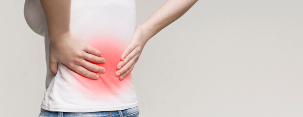 Back pain, kidney inflammation, woman suffering from backache, red inflamed zone, panorama