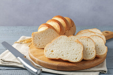 Sliced bread and knife on grey wooden table