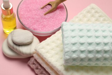 Plakat Clean waffle towels, cosmetic product, sea salt and spa stones on pink background, above view