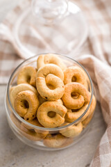 Salted crispy snack rings in jar on kitchen table.
