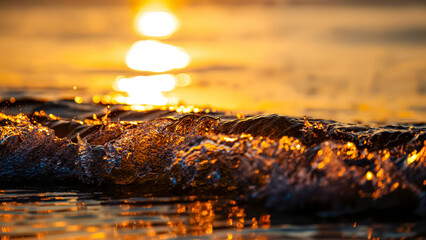 Golden ocean wave texture at sunset: sunlit water surface, liquid light reflection & splash. Abstract nature wallpaper, serene sea beauty.
